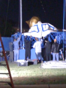 This is how things really get done-everybody knows what to do.  This is the very top structure of the tent being set up with canvas being attached to be pulled high in the air.